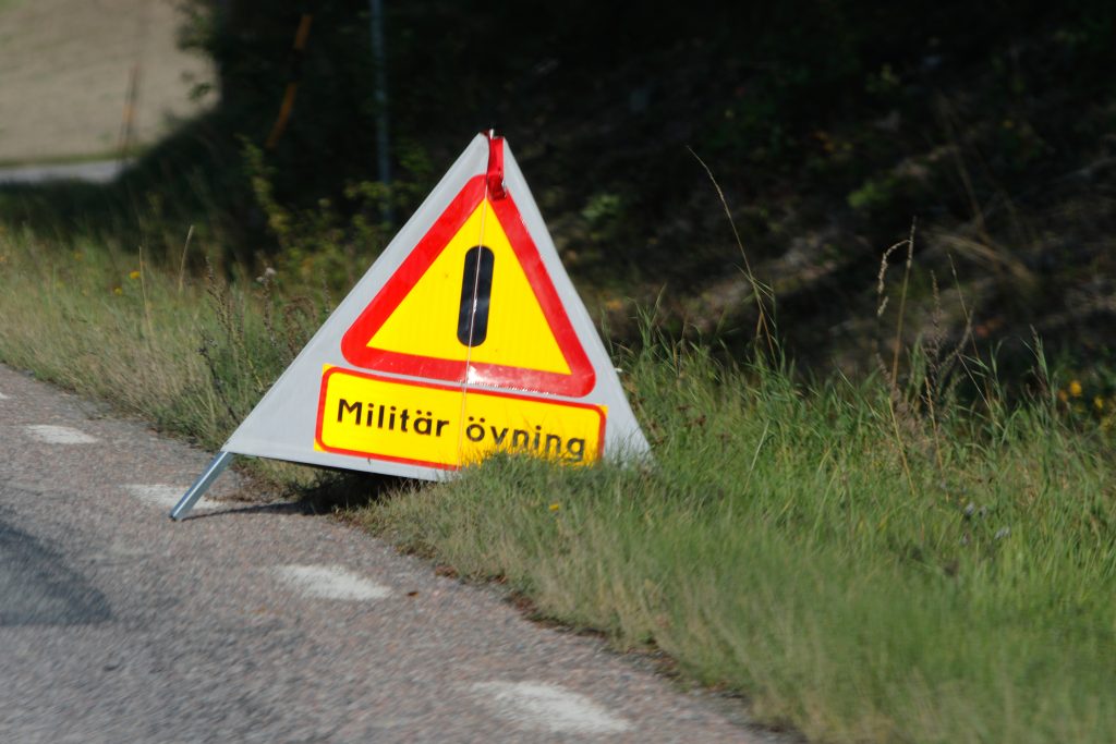 En skylt i en vägkant som varnar för en militär övning.